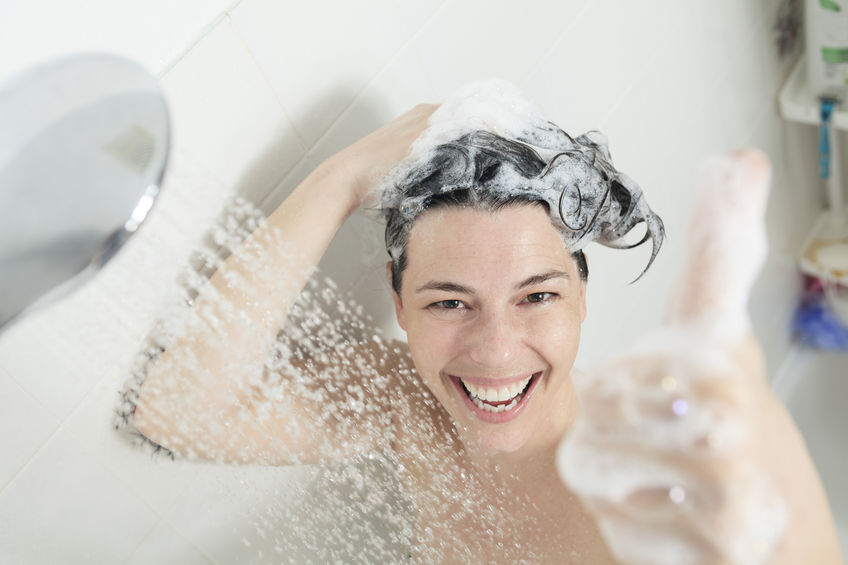Frau beim Duschen und Heizöl sparen